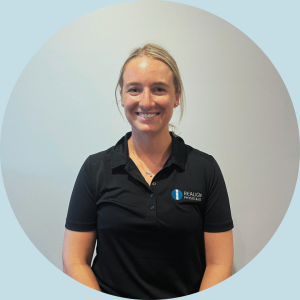 Sara Cloros, physiotherapist at Realign Physio & Co, smiling in a black polo shirt with the clinic logo, promoting personalised and evidence-based care.